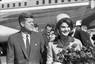 Image of the Kennedys smiling at the crowd at Love Field