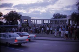 Image of flowers and crowds gathered in Dealey Plaza