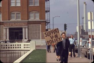 Image of protester in front of Texas School Book Depository