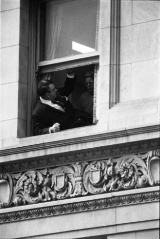 Image of people in a window above Main Street awaiting the motorcade
