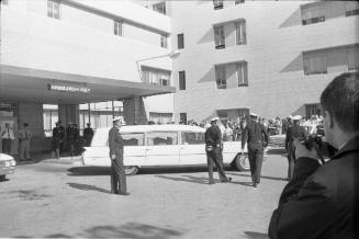 Image of a hearse backing into the emergency entrance bay at Parkland Hospital