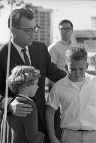 Image of man and children reacting to news of President Kennedy's death