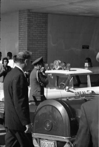 Image of a Secret Service agent and presidential limousine at Parkland Hospital