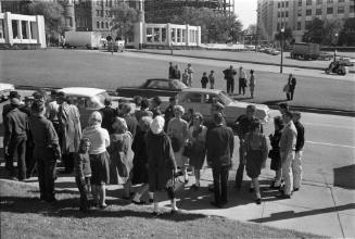 Image of a crowd gathered along Elm Street minutes after the assassination