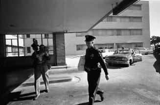 Image of a Dallas Police officer entering Parkland Hospital on November 24, 1963