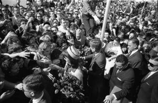 Image of President and Mrs. Kennedy greeting crowds at Love Field