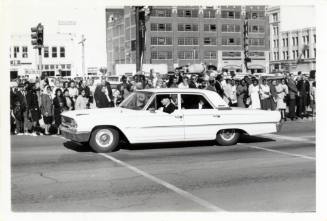 Black and white photograph of the pilot car of the Kennedy motorcade in Dallas