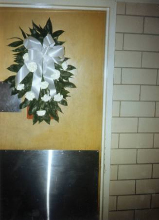 Color photo of flowers on the door to Trauma Room One at Parkland Hospital