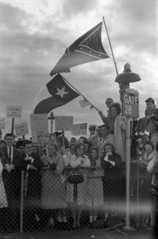 Image of the crowd holding signs and waving flags at Love Field