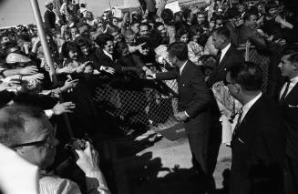 Image of President Kennedy shaking hands of members of the crowd at Love Field