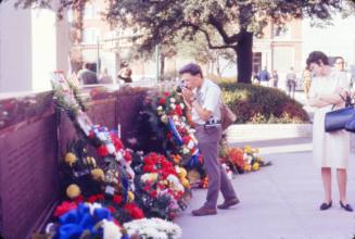Image of man taking photograph of flowers in Dealey Plaza