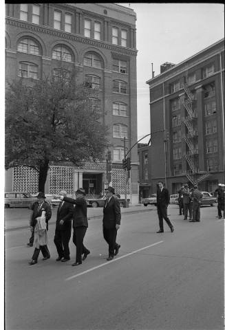 Image of members of the Warren Commission walking down Elm Street