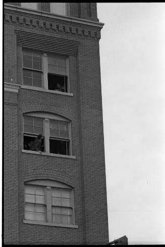 Image of men in the fifth and sixth floor corner windows of the Book Depository