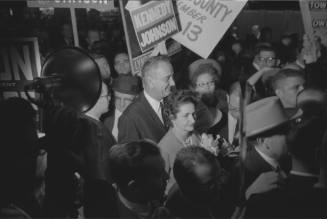 Lyndon and Lady Bird Johnson surrounded by a crowd during a Dallas campaign stop