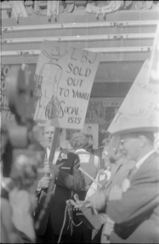 Image of a crowd of protestors carrying anti-LBJ signs in Dallas in 1960