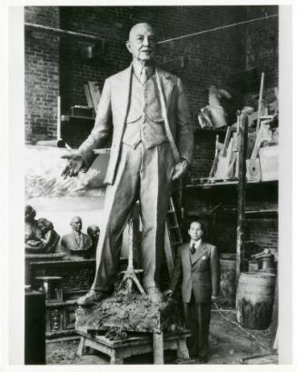 Photograph of Felix de Weldon next to statue of George Bannerman Dealey