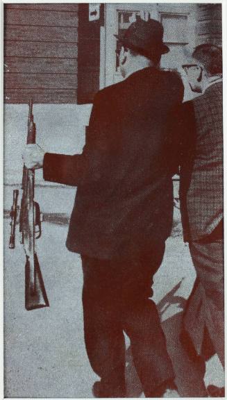 Photo printing plate of an officer carrying the rifle from the crime scene
