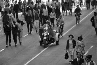 Image of a police motorcycle and the crowd on Main Street