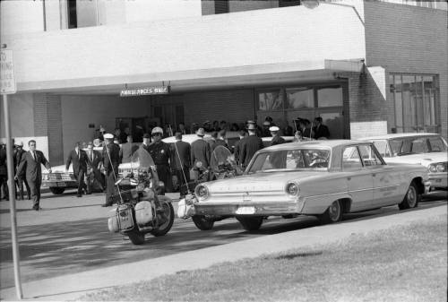 Image of the casket being loaded into a hearse at Parkland Hospital