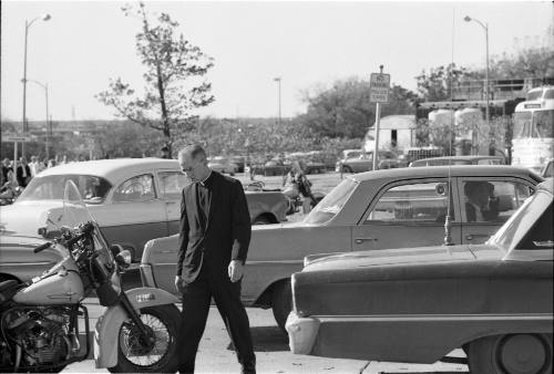 Image of a priest in the parking lot of Parkland Hospital