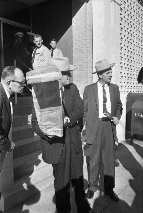 Image of Dallas Police detectives carrying evidence out of the Book Depository