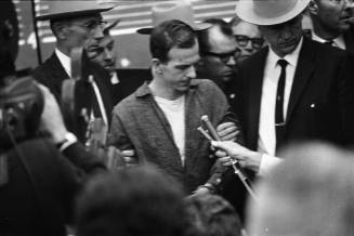 Image of Lee Harvey Oswald being led from the midnight press showing