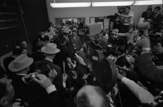 Image of Lee Harvey Oswald being escorted out of the midnight press showing