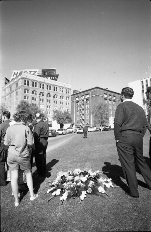 Image of people and flowers in Dealey Plaza the day after the assassination