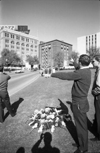 Image of people and flowers in Dealey Plaza the day after the assassination