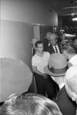Image of Lee Harvey Oswald in the hallway at the Dallas Police Department