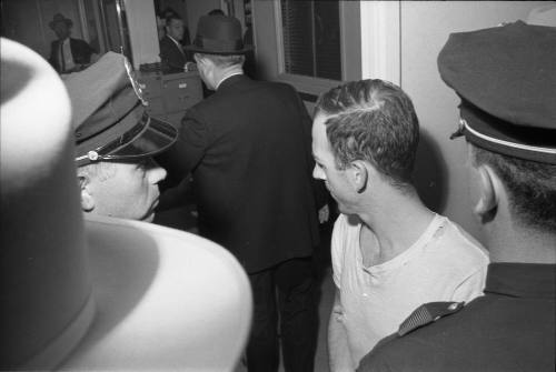 Image of Lee Harvey Oswald in the hallway at the Dallas Police Department