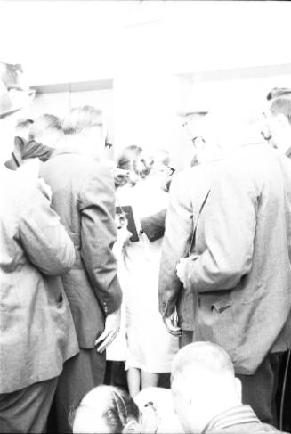 Image of Marguerite Oswald surrounded by the press at Dallas Police headquarters