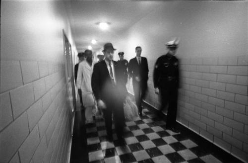 Image of police officers and others walking to the Parkland Hospital morgue