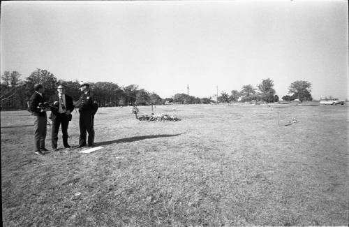 Image of reporters near Lee Harvey Oswald's grave at Rose Hill Memorial Park