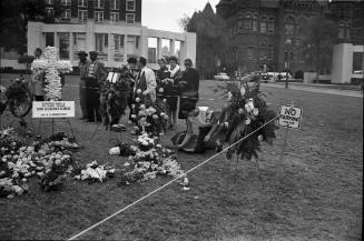 Image of crowd and memorial flowers in Dealey Plaza on November 27, 1963