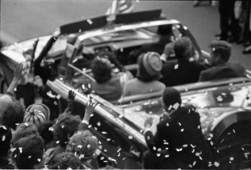 Image of the presidential limousine on Main Street, passing the Adolphus Hotel