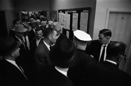 Image of Lee Harvey Oswald being escorted to the midnight press showing