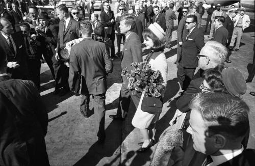 Image of the Kennedys walking toward the fence line at Love Field