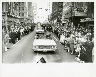 Black and white photo of the motorcade as it travels down Main Street