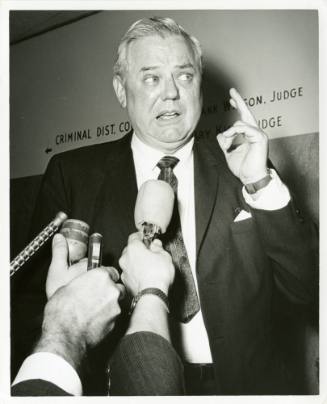 Photo of unknown man speaking to reporters in the Dallas County Criminal Courts