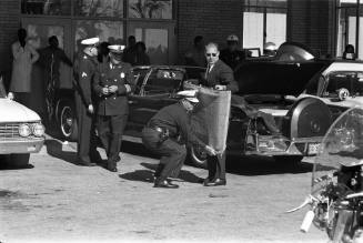 Image of police officers at Parkland dealing with evidence from the limousine