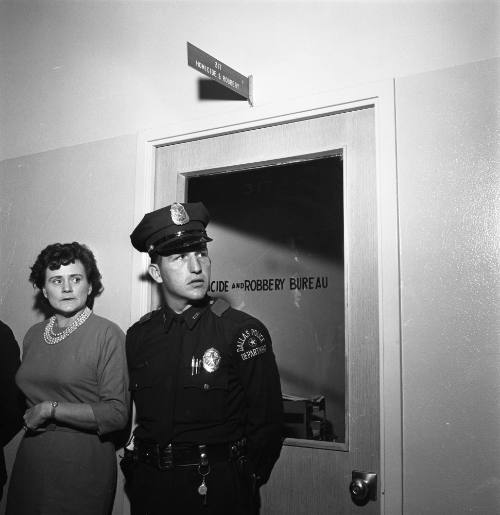 Image of a police officer guarding the Dallas Police Homocide & Robbery Office