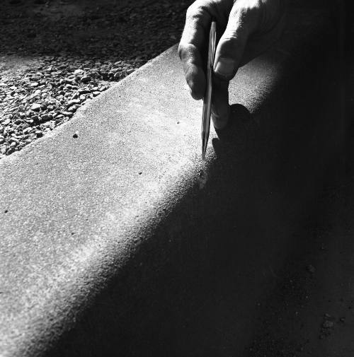 Image of a bullet mark on a curb in Dealey Plaza