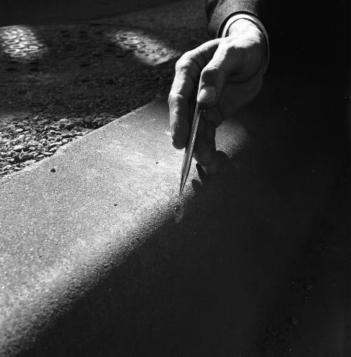 Image of a bullet mark on a curb in Dealey Plaza