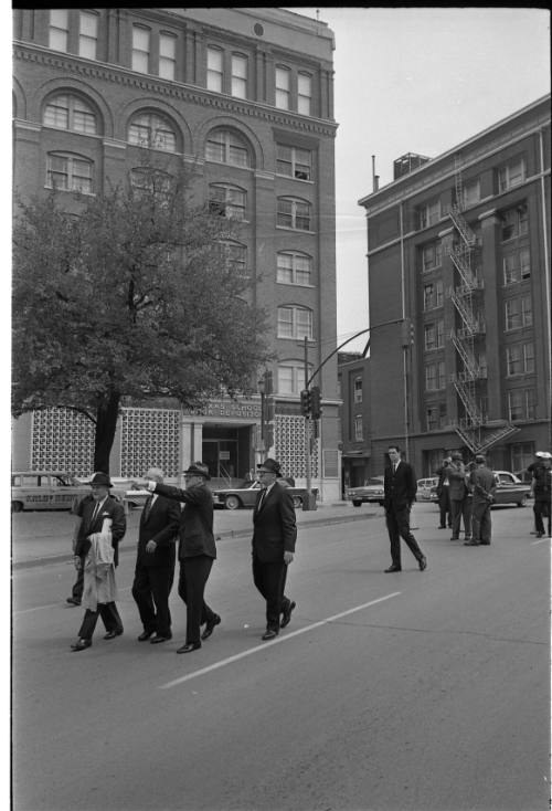 Image of members of the Warren Commission walking down Elm Street