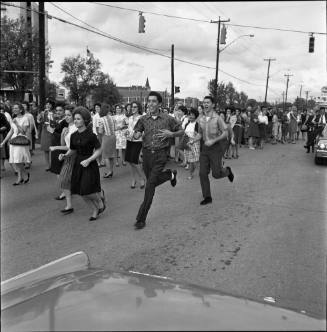 Image of a crowd chasing after the Kennedy motorcade in San Antonio