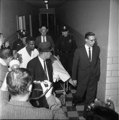 Police and medical examiner Earl Rose escort Oswald's body to the morgue