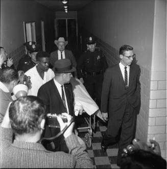 Police and medical examiner Earl Rose escort Oswald's body to the morgue