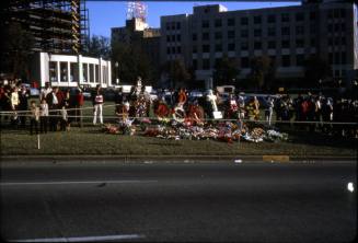 Image of mourners and memorial flowers in Dealey Plaza after the assassination