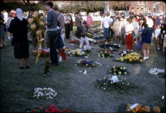 Image of mourners and memorial flowers in Dealey Plaza after the assassination